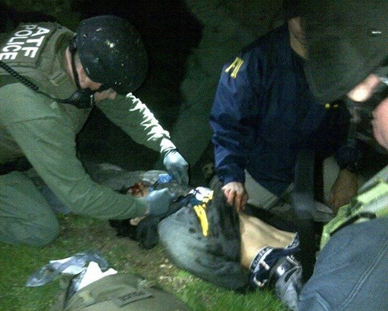 Federal agents attend to Dzhokhar Tsarnaev, 19, after he was apprehended late Friday in Watertown, Mass. He was hospitalized in serious condition under heavy guard Saturday as investigators continued piecing together the motive for the Boston Marathon bombings and the scope of the plot. His brother, Tamerlan Tsarnaev, 26, died after a gunbattle with police.