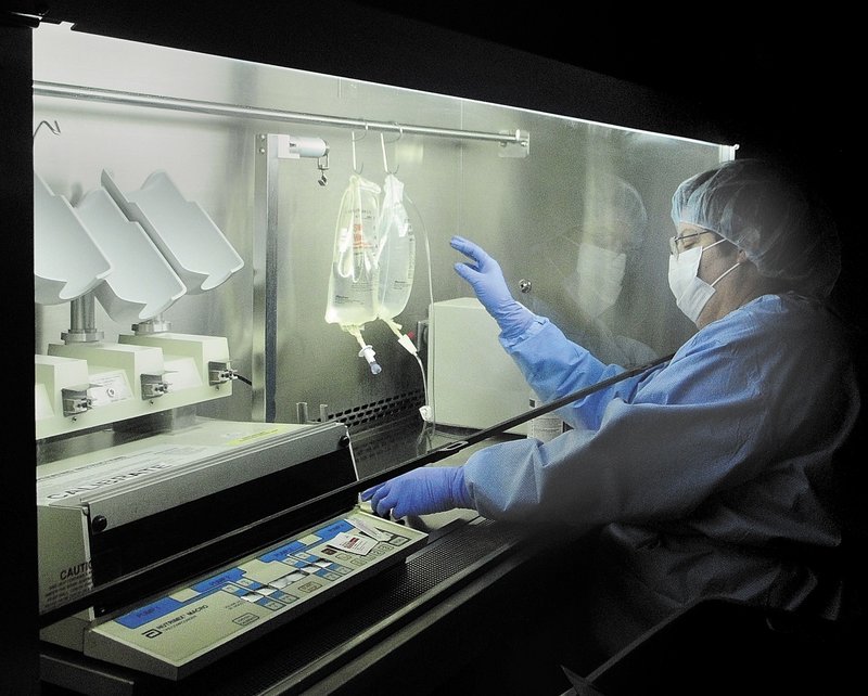 Pharmacy technician Suzanne Goddard works under a hood preparing bags of intravenous medicines in the sterile room at Kennebec Pharmacy & Home Care in Augusta.