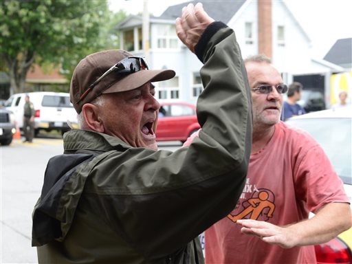 Angry citizens heckle Rail World Inc. President and CEO Edward Burkhardt as he tours Lac-Megantic, Quebec, on Wednesday.