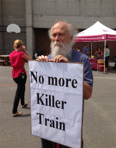 Richard LeFebvre, of the nearby town of St. Romain, awaits the arrival Wednesday of Edward Burkhardt, president and CEO of the railway company that owns the train that derailed in Lac-Megantic, Quebec.