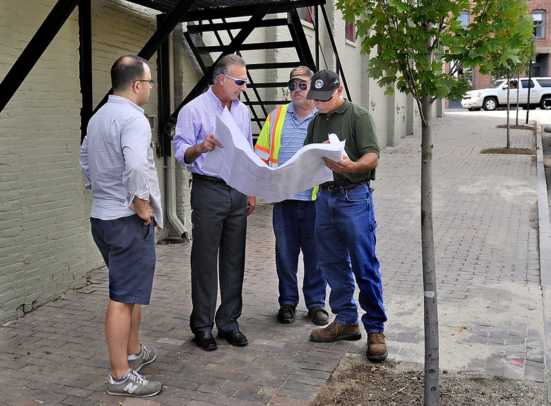 Baxter Academy's chief operating officer Adam Burke, left, looks on Wednesday, Aug. 28, 2013 as general contractor Dan LaBrie of Rufus Lumber, owner of the property, second from left, discusses the completion of improvements to the property with Phil DePierro of the Portland Planning Department, right, and Greg Vining from Public Services, third from left.