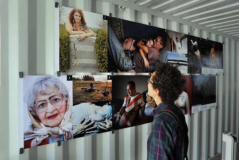 Ouda Baxter of Portland views the “Photoville ME” images created by students of Portland’s SALT Institute for Documentary Studies.