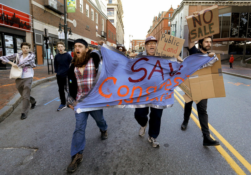 Left to right, Matthew Coffey, Carl McKenney and Michael Anthony lead a march down the center of Congress Street to City Hall on Monday, September 16, 2013, to protest the sale of Congress Square Plaza.