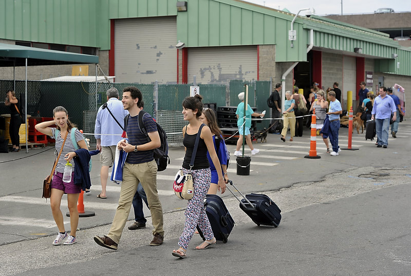 Travelers head to the Peaks Island Ferry Saturday. Behind them is the Casco Bay Ferry Terminal in Portland. Groundbreaking for terminal upgrades takes place Wednesday.