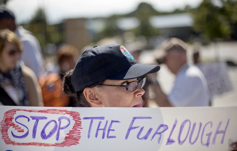 Andrea Bentley, with the American Federation of Government Employees, protests the government shutdown outside the Centers for Disease Control and Prevention in Atlanta. About two dozen people protested Tuesday afternoon outside the CDC, trying to cast a harsh spotlight on the temporary federal shutdown. The small group called on Congress to vote on a measure that would restart federal funding.