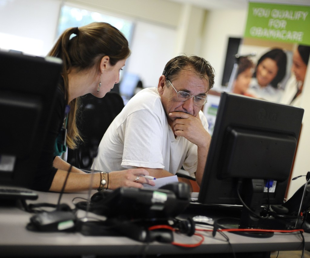 Shannon Bali helps Boguslaw Dudek enroll in the new health insurance system Tuesday at the Community Health Center in New Britain, Conn. Despite design recommendations, the federal website does not allow for window shopping.