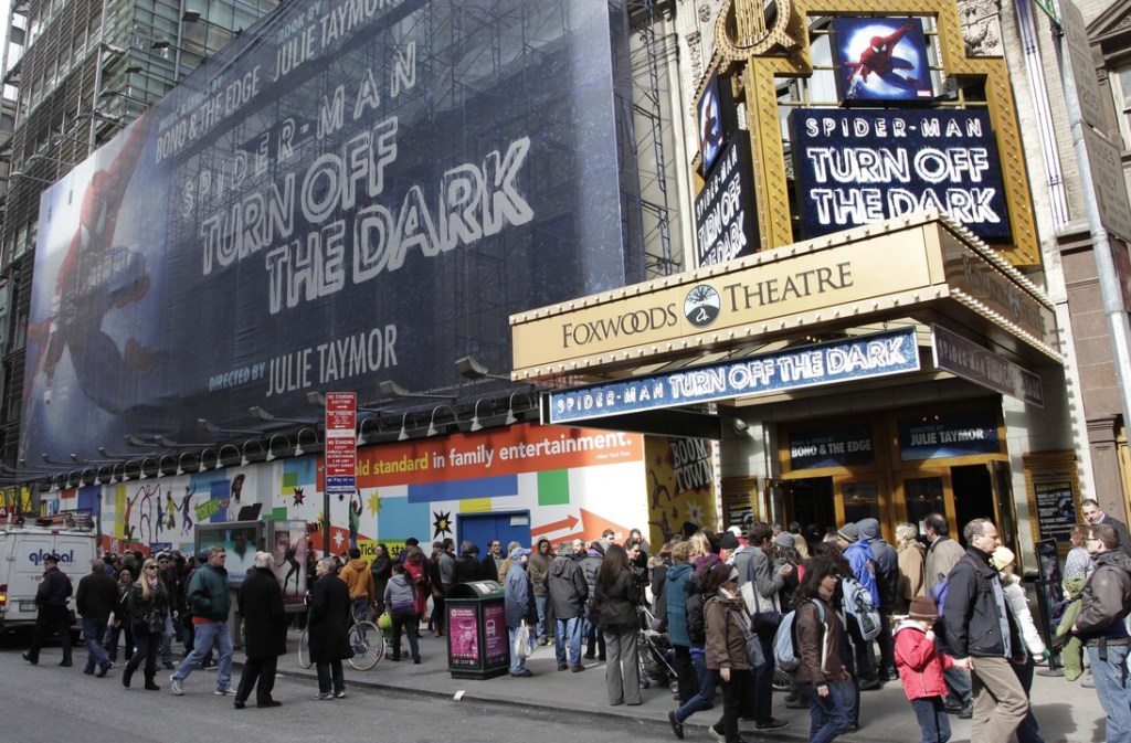 FILE - In this March 9, 2011, file photo, people line up to enter the Foxwoods Theatre for a matinee showing of “Spider-Man: Turn Off the Dark,” in New York. Producers are turning the lights off forever on the Spider-Man musical on Broadway in early 2014, the final chapter in the story of most expensive theatrical show ever that shook off a troubled launch to become a hit and is now limping away to Las Vegas.