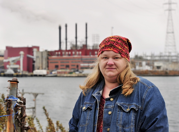 Kim Richards, founder of Citizens for Clean Air, stands across the Piscataqua River from the Schiller Station’s four smokestacks.