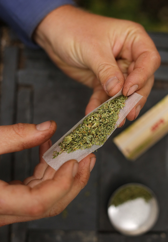 A smoker rolls a marijuana cigarette in Portland last month. The city’s electorate legalized recreational use of the drug last week, but federal and state laws still trump the local change.