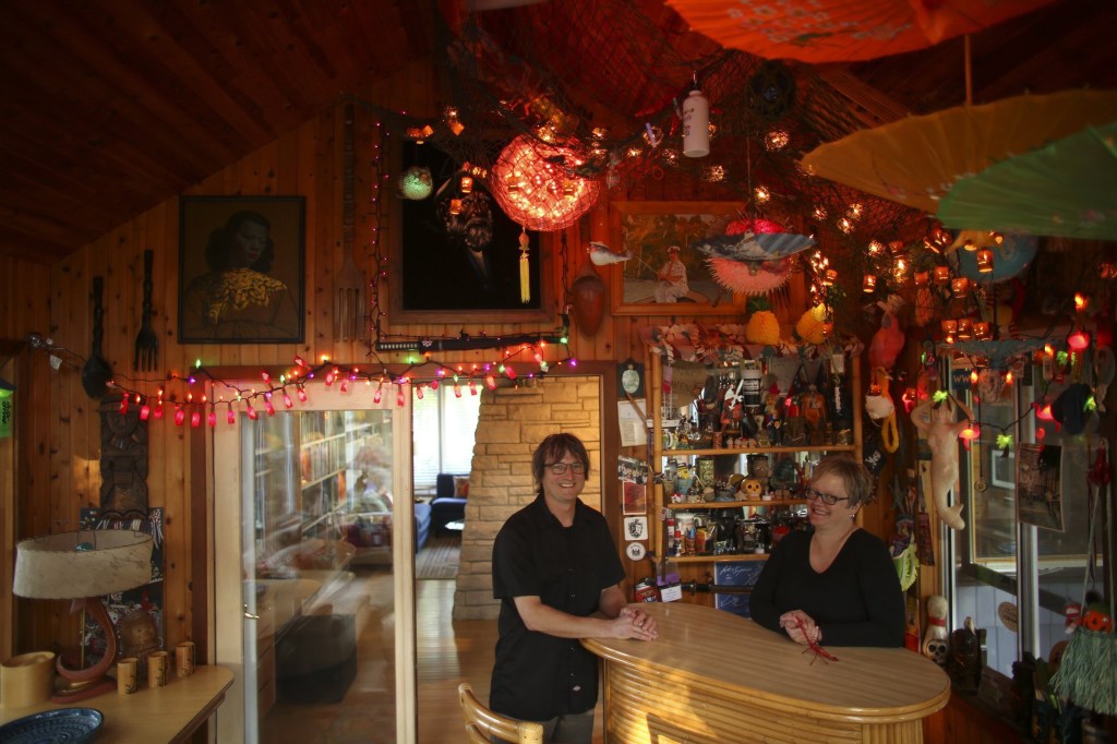 Charbonneau and Berven stand in the Tiki-themed porch at their remodeled ranch home.