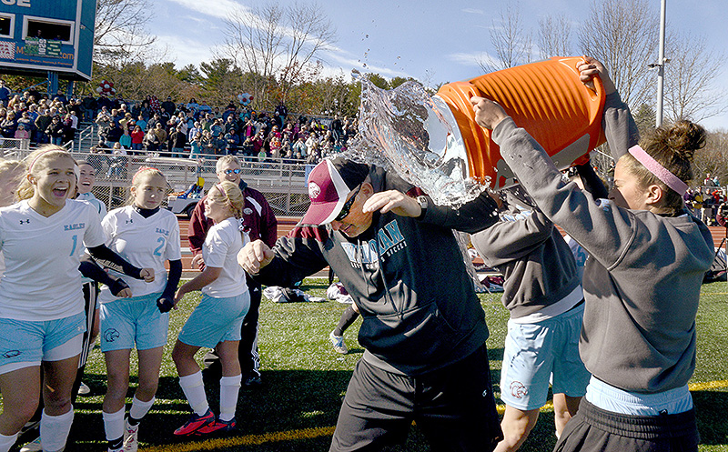 Jeff Fish, Windham’s assistant coach, gets doused with a cooler of water after Windham defeated Bangor for the Class A girls’ state soccer championship at McMann Field in Bath. GirlsAsoccer