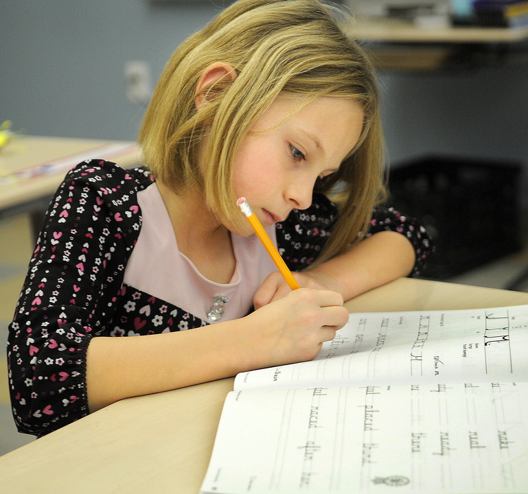 Chelsea Elementary third-grader Chloe Smiley works on a cursive lesson during a recent class.