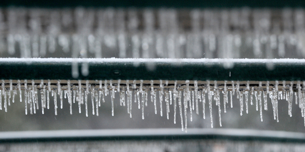 Icicles drip from the edges of picnic tables at Quarry Road Recreational Area as the ice storm rolls through Waterville on Sunday.