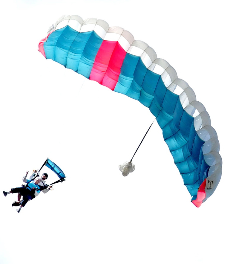 Marjorie Bell, in front, who turned 80 last week, enjoys the ride of her life as she floats under a parachute to a large and cheering group of family members at the LaFleur Airport in Waterville on Sunday.