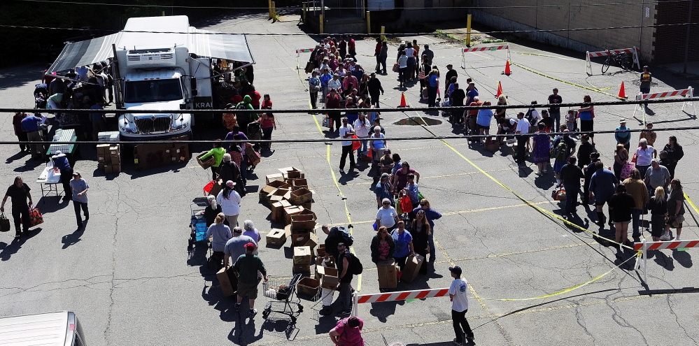 Photos by Joe Phelan/Knnebec Journal A line forms for the Good Shepherd Food Mobile on Friday on Willow Street in Augusta. There were no limitations on residency.