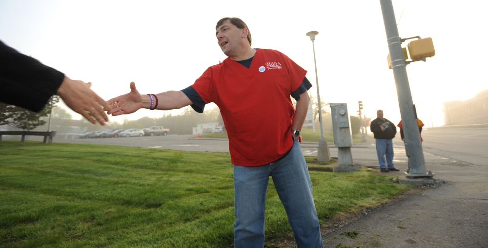 Troy Jackson greets hospital workers in front of Eastern Maine Medical Center in Bangor recently. Kevin Bennett photo