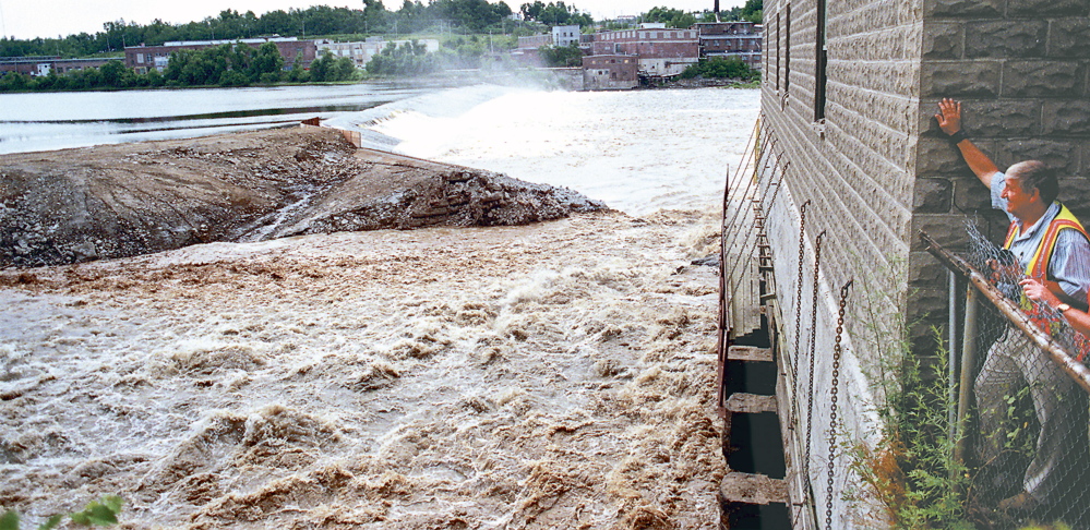 John Charest, Augusta’s public works director, watches the Kennebec River flow through the breach from the Edwards Dam block house.