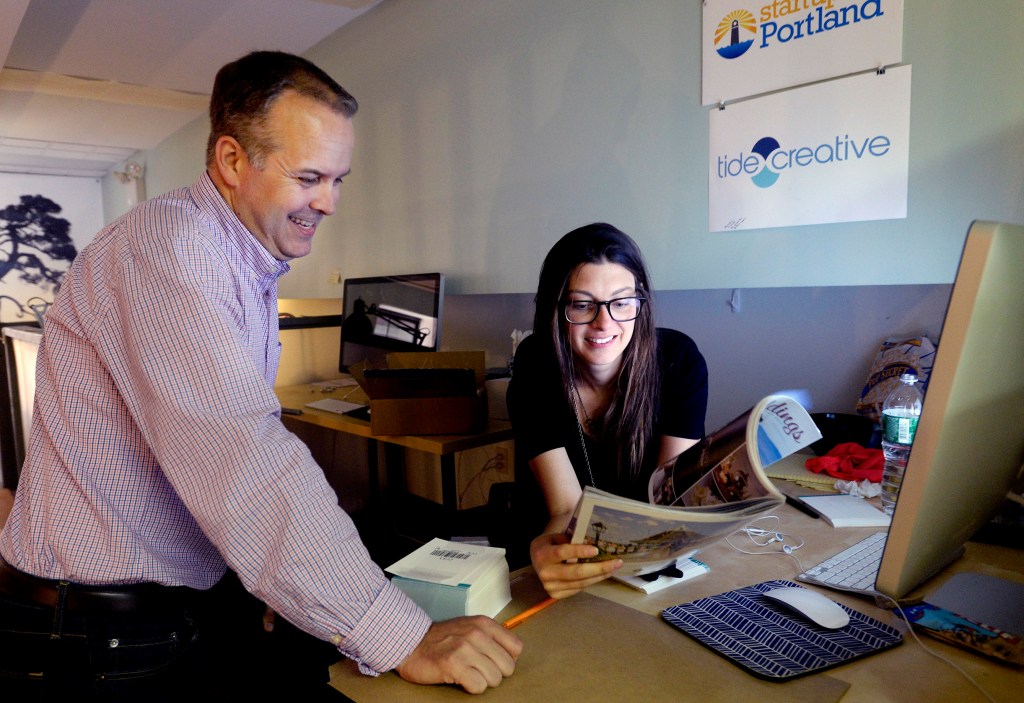 J Sandifer and Liz Kirby of Tide Creative look over ads the company placed in a magazine recently. Shawn Patrick Ouellette/Staff Photographer