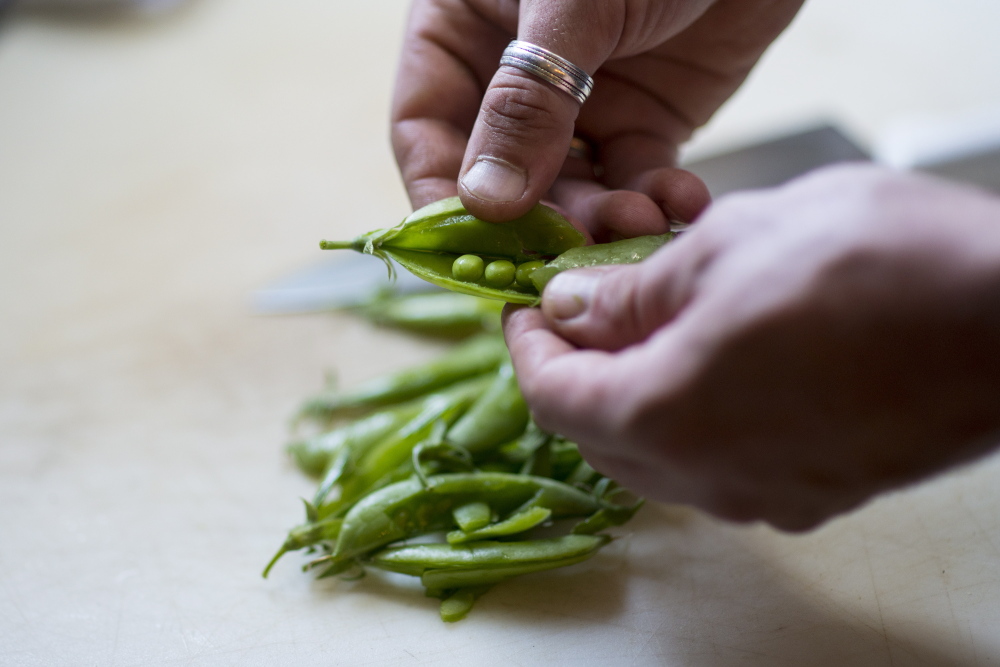 Chef Bryan Dame prepares fresh vegetables at Gather in Yarmouth. Owner Matt Chappell has begun a barter program that trades restaurant credit for homegrown produce. Logan Werlinger/Staff Photographer