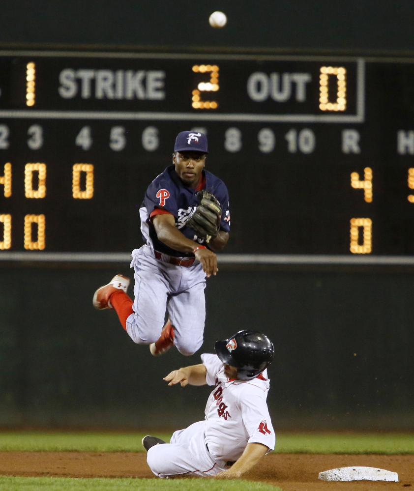 Albert Cartwright of Reading leaps away from the sliding Sean Coyle of the Portland Sea Dogs and throws to first to complete a double play Wednesday night during Reading’s 5-2 victory at Hadlock Field.