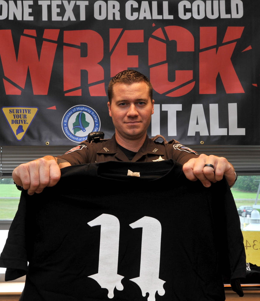 Nick Oettinger, Mount View School resource officer, holds up a Project 11 T-shirt. The number 11 indicates that 11 teenagers die each day in accidents caused by texting while driving.