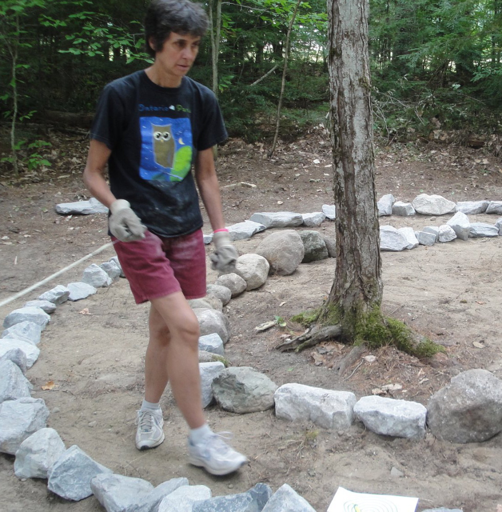 The Rev. Nancy Foran, pastor of the Raymond Village Community Church, lays out the lines for a labyrinth she had installed at her home a few years ago.