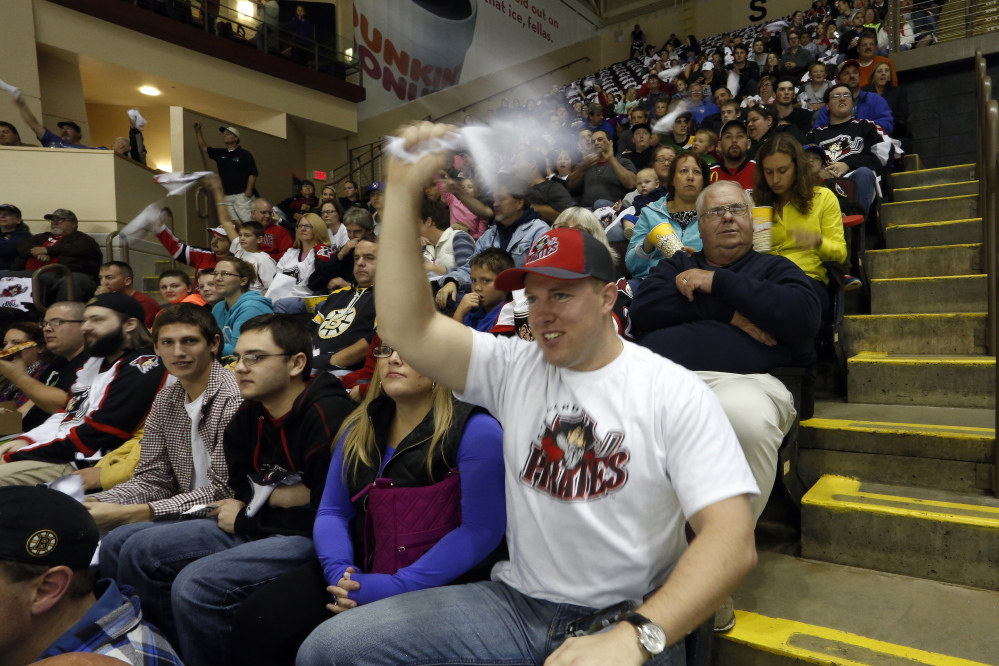 Eric McGough of Caribou waves a towel as the Portland Pirates take the ice for their season opener Saturday night against the Providence Bruins at the Cross Insurance Arena. The Pirates won, 3-2.