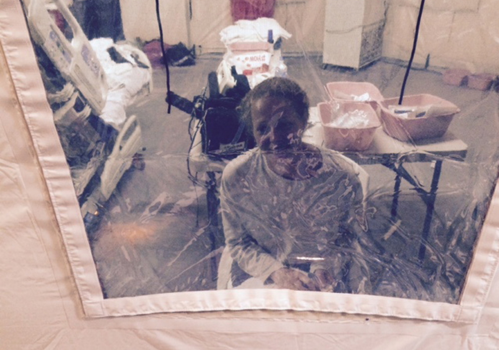 Nurse Kaci Hickox looks through the plastic “window” of an isolation tent outside a New Jersey hospital where she had been quarantined for days after arriving by plane from West Africa. Hickox, who was free of Ebola symptoms, was released Monday.