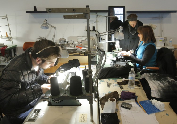 Evan Michael, left, Roxi Suger, standing, and Denise Laverriere work in the new production facility of Angelrox, a clothing line that Suger produces in the Pepperell Center in Biddeford. The line is sold in about 300 stores nationwide.