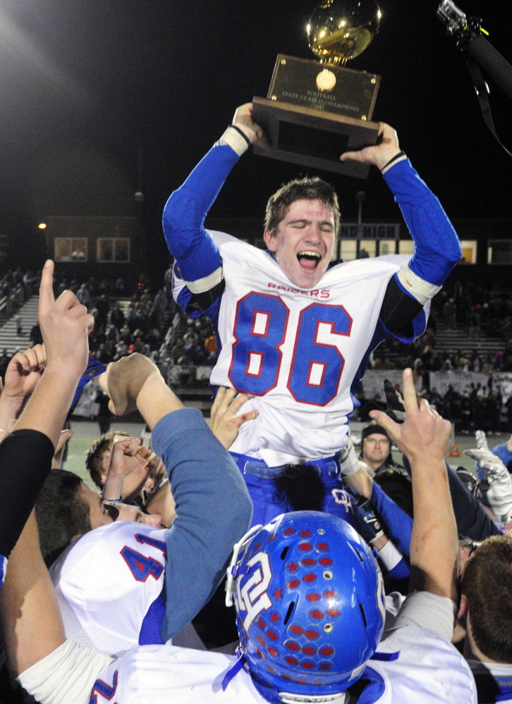 Oak Hill’s Samson Lacroix holds aloft the Gold Ball after the Raiders beat Maine Central Institute 41-21 to win their second straight Class D state championship.