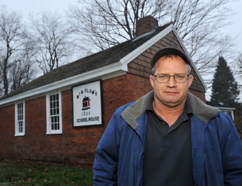 Winslow Councilman Raymond Caron, former vice president of the now defunct Winslow Historical Society, stands in front of the Winslow schoolhouse on Wednesday. He estimates that the town would need to budget $1,000 to $2,000 per year for the building’s upkeep.