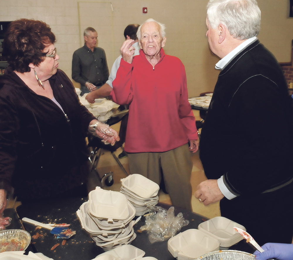 Bud King, center, speaks with volunteers preparing meals Thursday during the annual Thanksgiving dinner at Messalonskee High School in Oakland.