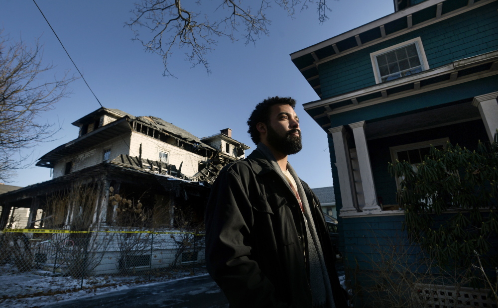 Zach Darwin, standing in front his Noyes Street apartment building, says the charred building next door is a constant reminder of the tragedy of Nov. 1, when six young adults died in a fire there. “It hurts to see this every day. My girlfriend and I are moving out,” he said.