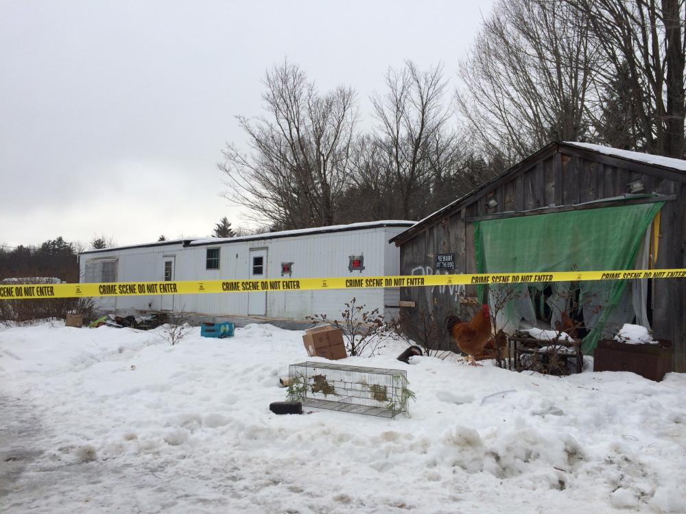 Yellow caution tape hangs across the yard at 1130 Weld Road, where Dana “Mikey” Craney lived with his grandmother, Joanne Goudreau. Craney was charged with murder early Sunday morning after police found Goudreau’s body in the backyard.