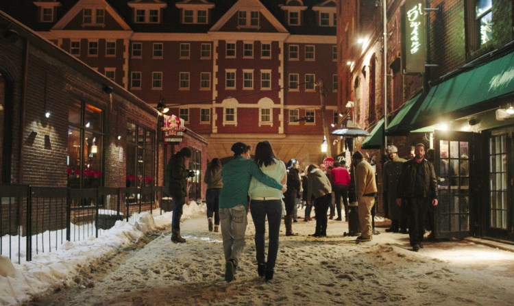 Patrons of bars and nightclubs walk along Wharf Street after the 1 a.m. closing time Saturday, not far from the towering Portland Harbor Hotel. Although the bars and clubs appear to be conforming to the law on noise levels, hotel guests say it’s too loud for them.