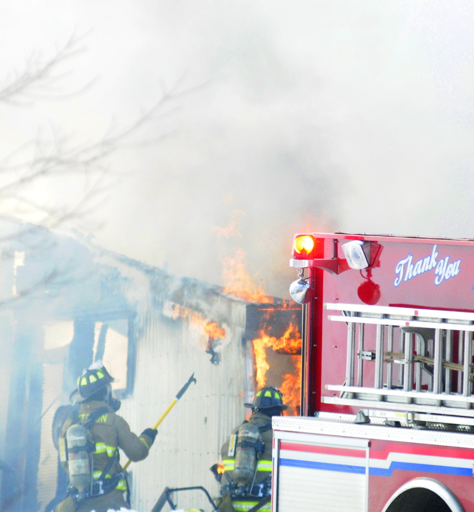 Firefighters pull back walls to expose fire as they extinguish a barn at 845 Northern Ave. in Farmingdale on Wednesday.