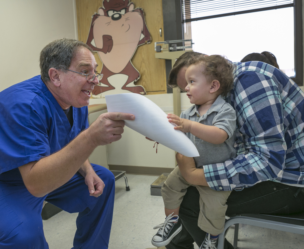 Pediatrician Charles Goodman talks with Carmen Lopez and her 18-month-old son Daniel after he was vaccinated at Goodman’s practice in Northridge, Calif., Thursday.