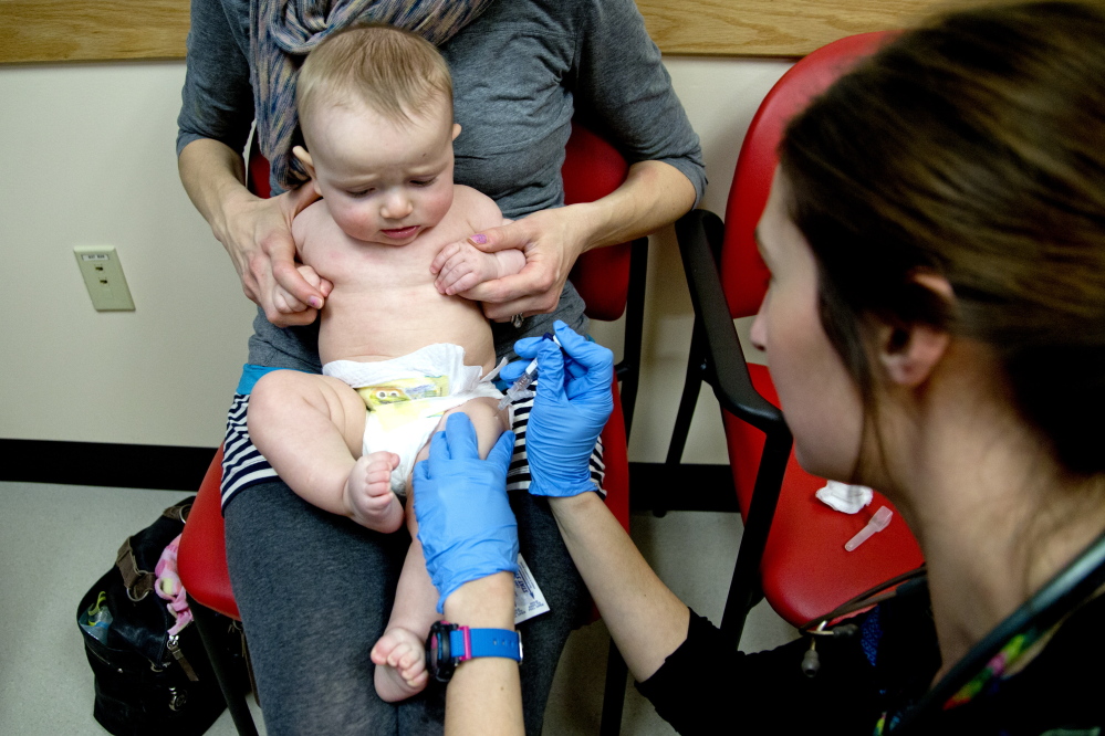 Bethany Hickey holds Alexander as he is vaccinated by clinical assistant Laura Boyer at Intermed Pediatric Care. Hickey worries about giving her children too many shots all at once, but nevertheless believes in the value of vaccinations. “If enough people go without vaccinations, it’s a health risk to the general population,” she said.