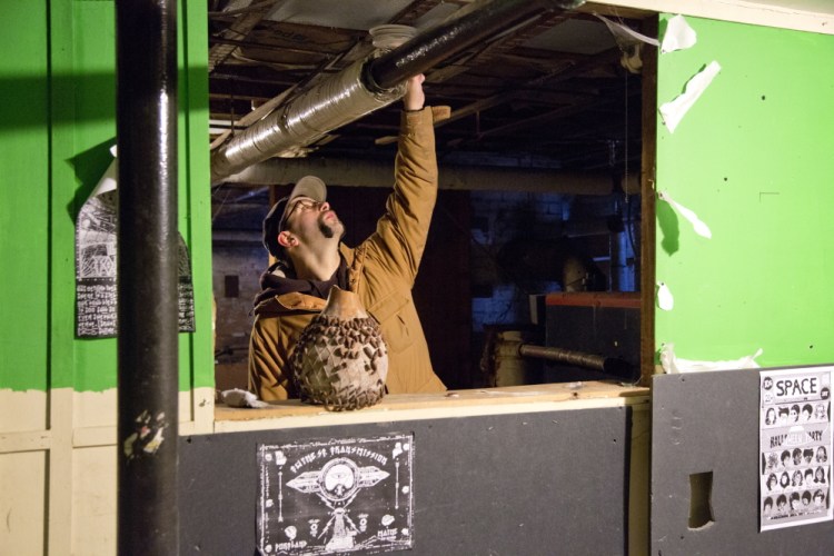 Chris Kidder, 31, of Portland, checks a smoke detector Friday in the basement of 188 Dartmouth St. in Portland, where he used to live before it was deemed uninhabitable.