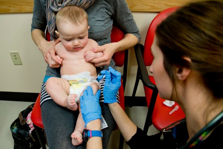 Bethany Hickey holds her 6 month old son, Alexander while he receives a Prevnar Pneumococcal Meningitis vaccine from clinical assistant Laura Boyer at Intermed Pediatric Care in South Portland on Feb. 5, 2015.