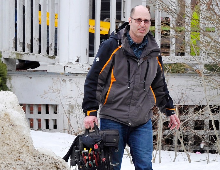 Owner Gregory Nisbet carries tools for an electrical crew from his building at 188 Dartmouth St. in Portland prior to an inspection Tuesday.