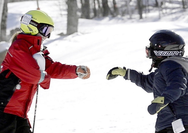 Keegan Moreau, 16, left, fist-bumps David Botana, 12, after a run down the mountain at Sunday River in Newry.