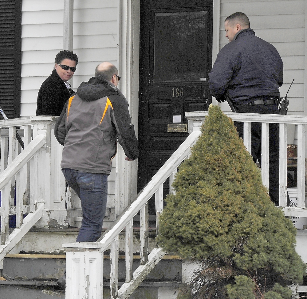 Tammy Munson, Portland's director of inspection services, left, and Chuck Fagone, code enforcement officer, right, greet owner Gregory Nisbet at 188 Dartmouth St. before a final inspection Tuesday. (Gordon Chibroski/Staff Photographer)