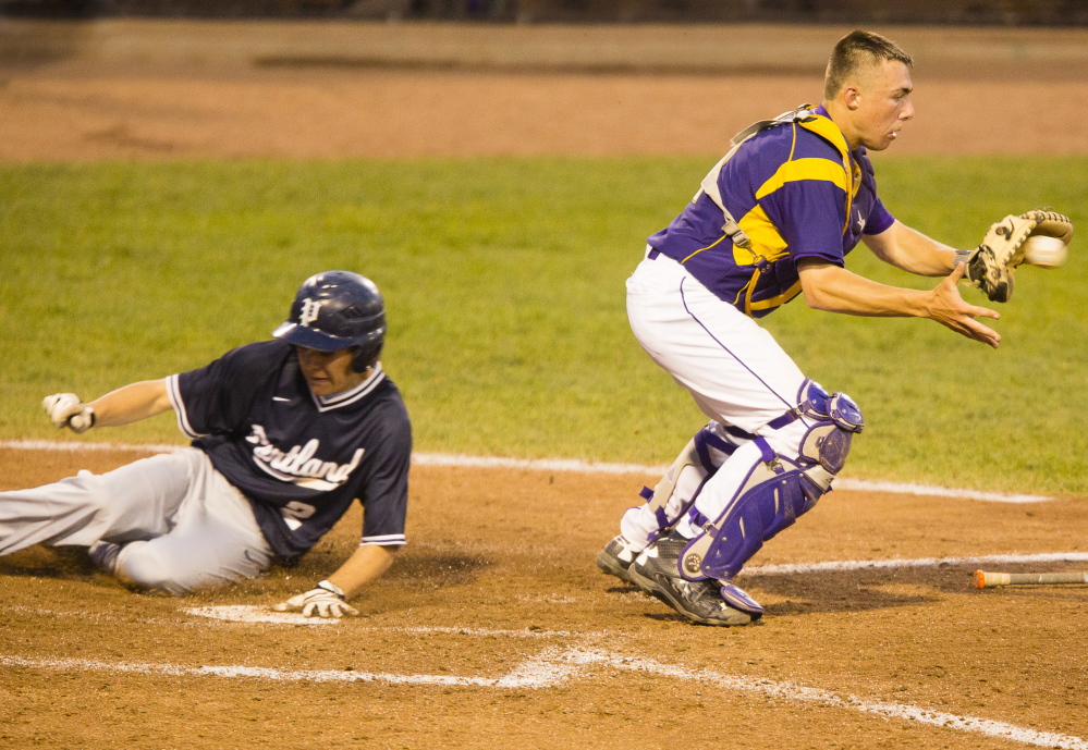 Portland baserunner Dom Tocci slides safely into home as Cheverus catcher Logan McCarthy takes a late throw during a fifth inning rally in which Portland tied the game at 6 in varsity boys baseball at Hadlock, Field Tuesday. (Carl D. Walsh/Staff Photographer)