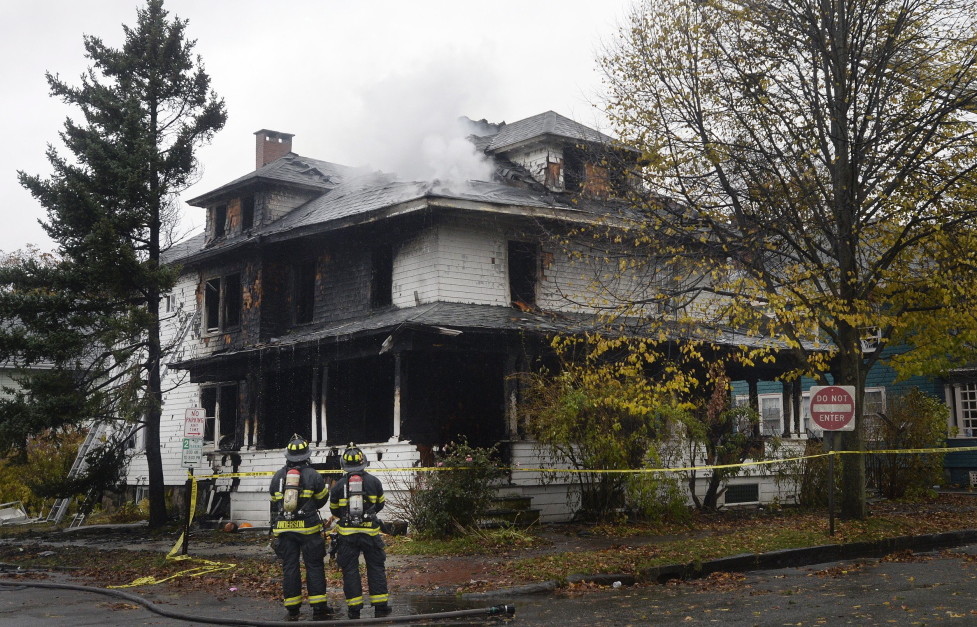 Firefighters examine the building at 20-24 Noyes St. shortly after a fire killed six young adults Nov. 1. Fire officials have said none of the smoke detectors was working at the time.