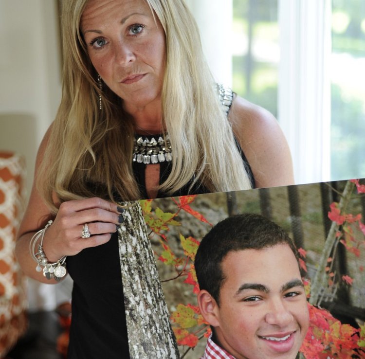 Nancy Laxson holds a photo of her son, Treyjon Arsenault, who was killed in the Old Port in May, in this June file photo. She said Monday, after the arrest of Gang Deng Majok, "It’s two more people off the streets that won’t hurt anyone else."