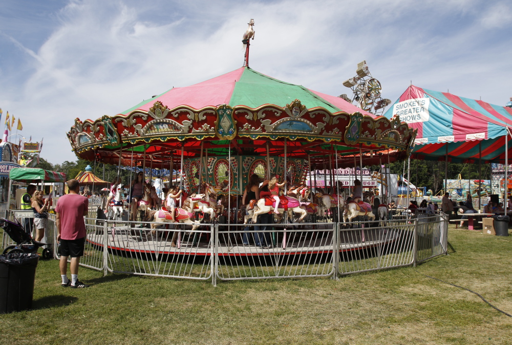 YARMOUTH, ME - JULY 17: Parents and children ride on a carousel at the Yarmouth Clam Festival, Friday, July 17, 2015 in Yarmouth, Maine. The carousel had been shut down after a malfunction earlier in the day. (Photo by Joel Page/Staff Photographer)