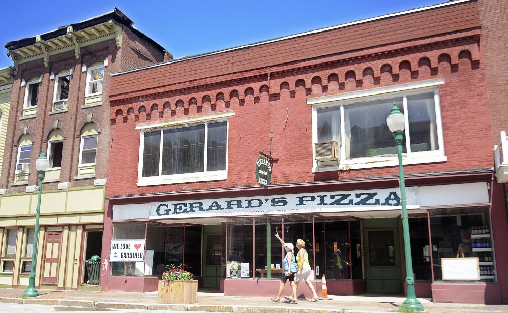 GARDINER, ME - JULY 20: People walk Monday July 20, 2015 past Gerard's Pizza in Gardiner devastated by fire. (Staff by Andy Molloy/Staff Photographer)