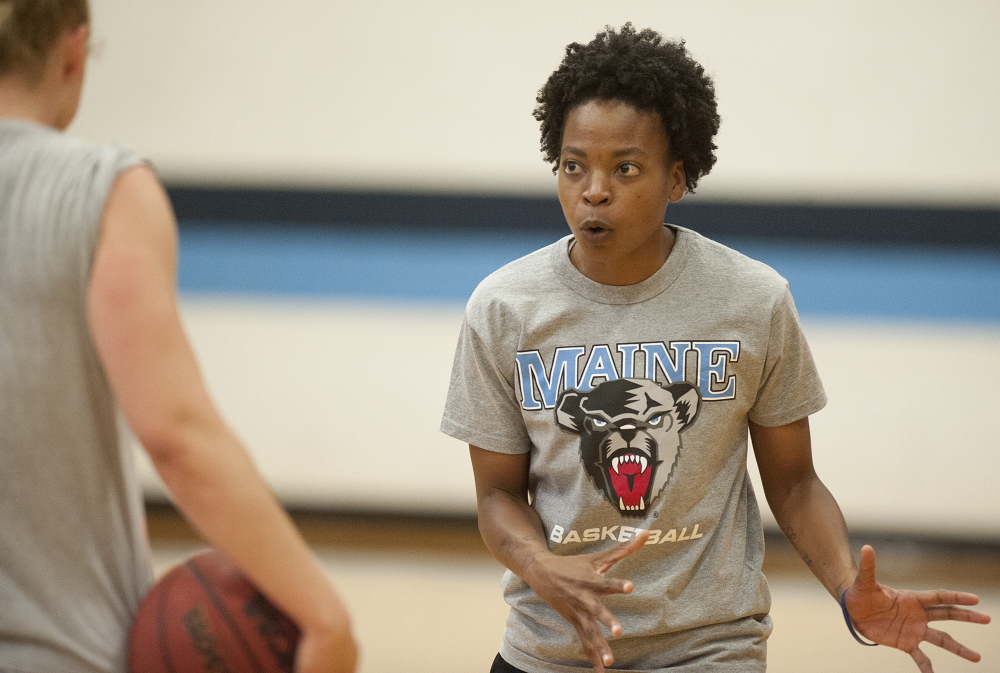 University of Maine women’s basketball coach Edniesha Curry works out with student-athlete Liz Wood, far left, at the Memorial Gym recently. Wood said she was sold on Maine because of the vision coaches had for restoring pride in a program that had fallen on tough times.