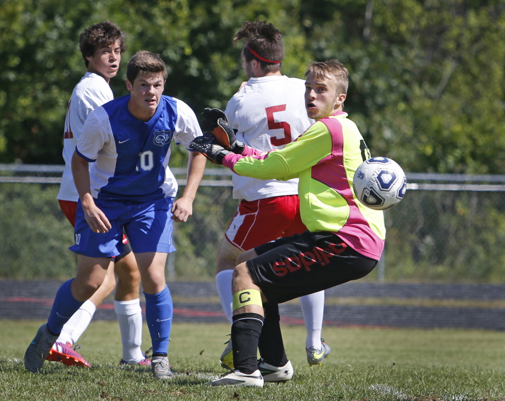 Kennebunk’s Andrew Rudowski, 10, and Wells goalie Nick Chandler watch as the ball sails past the goal in the first half Saturday at Wells.